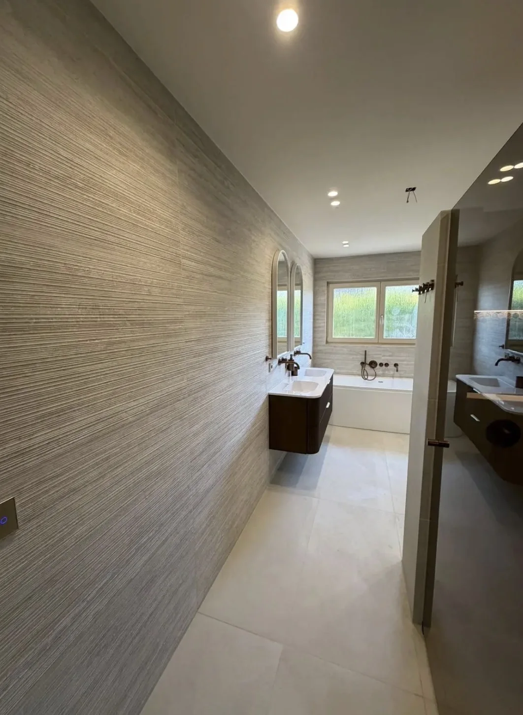 Overzicht van een lichte badkamer met bad en wastafelmeubel